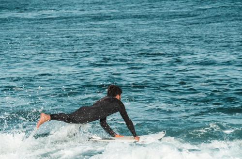 a man riding a wave on a surfboard in the ocean at Buendía Corralejo Nohotel in Corralejo
