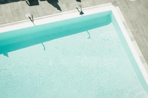 uma vista superior de uma piscina com duas cadeiras em Apartamentos El Palmar em Playa del Inglés