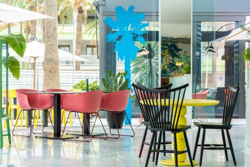 een groep stoelen en tafels in een restaurant bij Gold Playa del Ingles - Adults Only in Playa del Inglés