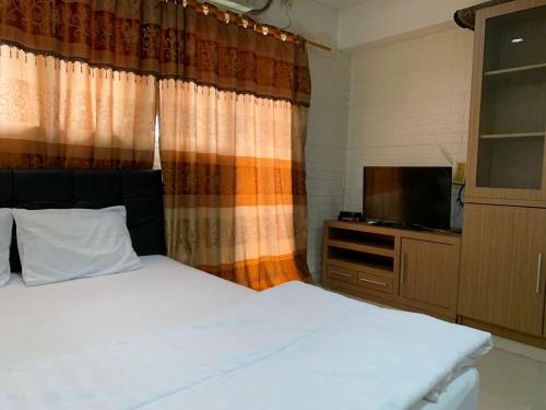 een slaapkamer met een bed en een flatscreen-tv bij RedLiving Apartemen Sentra Timur - YN Idea Property Tower Kuning in Jakarta
