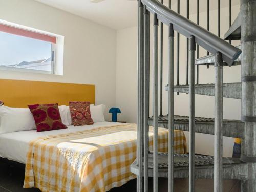 a bedroom with a bed and a spiral staircase at Buendía Corralejo Nohotel in Corralejo