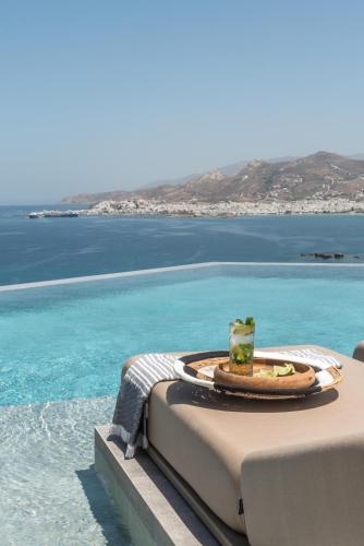 a table with a drink on the edge of the ocean at Virtu on the Hill in Stelida