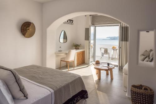 a bedroom with a bed and a view of the ocean at Virtu on the Hill in Stelida