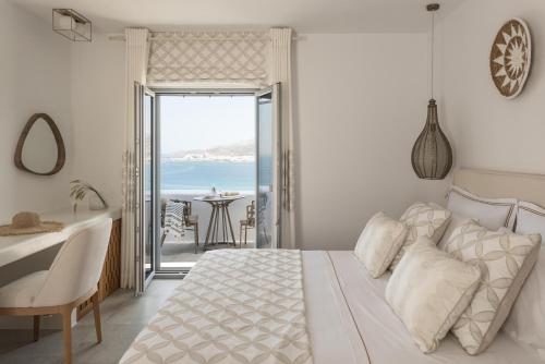 a bedroom with a bed and a view of the ocean at Virtu on the Hill in Stelida
