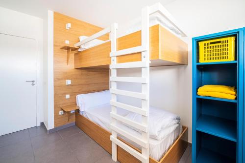 a bunk bed in a small room with a ladder at Buendía Corralejo Nohotel in Corralejo