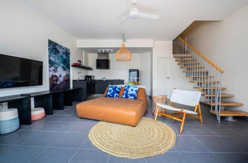 a living room with a couch and a tv and stairs at Buendía Corralejo Nohotel in Corralejo