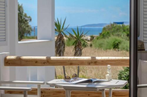 una mesa con vistas a la playa desde una ventana en Glaronissi Beach, en Plaka