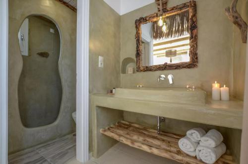 y baño con lavabo, espejo y toallas. en Glaronissi Beach, en Plaka