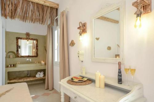 een badkamer met een witte wastafel en een spiegel bij Glaronissi Beach in Plaka