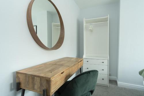 a dressing table with a mirror and two chairs at Heath House in Burton upon Trent