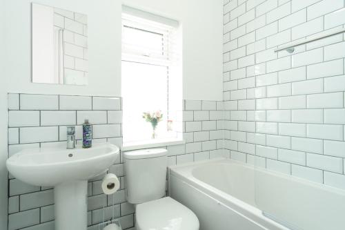 a white bathroom with a toilet and a sink at Heath House in Burton upon Trent
