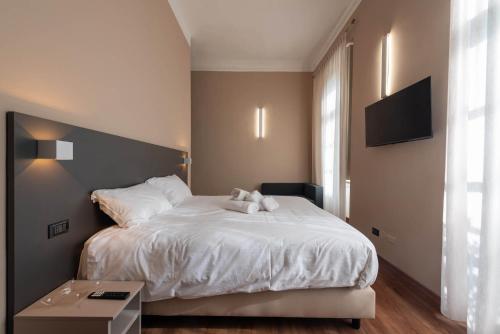 a bedroom with a white bed with a teddy bear on it at Torino Station Relais in Turin