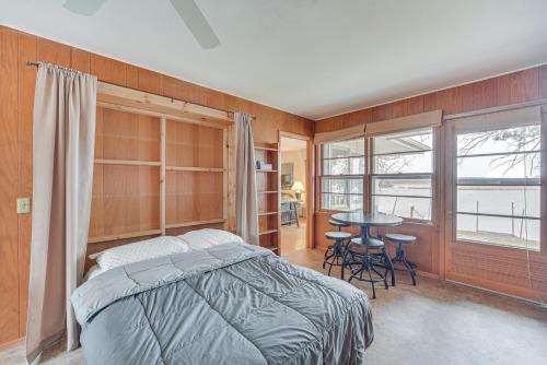 a bedroom with a bed and a table with chairs at Waterfront Lake Holcombe Getaway with Dock in Conrath