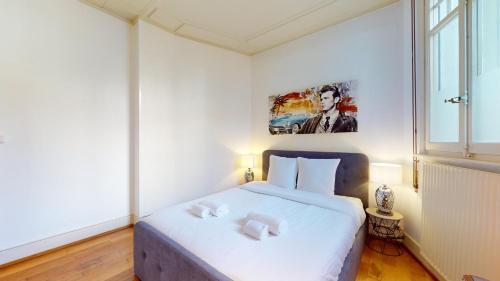 een slaapkamer met een wit bed en 2 handdoeken bij Authentic apartment in the heart of Vevey in Vevey