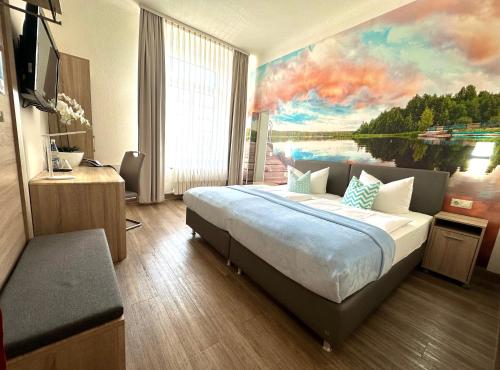 - une chambre avec un grand lit orné d'une peinture murale dans l'établissement Hotel "Central" Inh Carolin Krause, à Bitterfeld