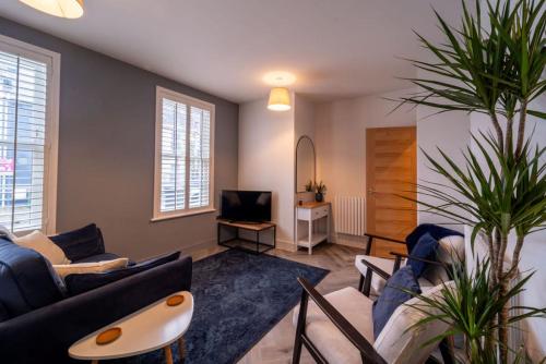 a living room with a couch and a tv at Buckingham Court in Cheltenham