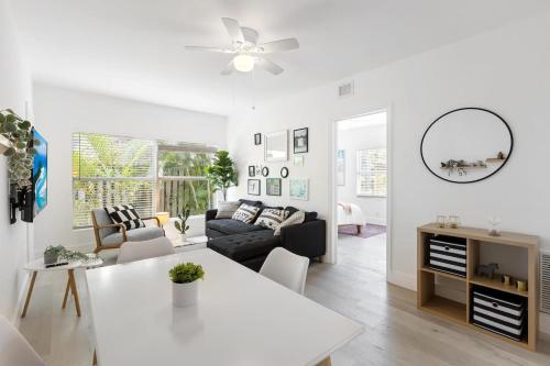 a white living room with a couch and a table at Charming 2 Bedroom Apartment in Victoria Park in Fort Lauderdale