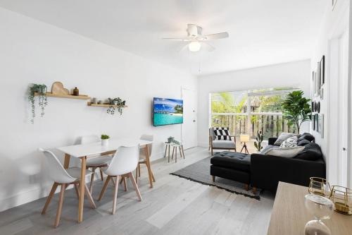 a living room with a black couch and a table at Charming 2 Bedroom Apartment in Victoria Park in Fort Lauderdale