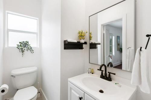 Un baño blanco con lavabo y espejo. en Charming 2 Bedroom Apartment in Victoria Park, en Fort Lauderdale
