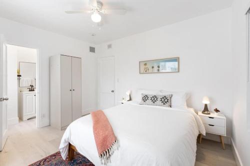 Un dormitorio blanco con una cama y un ventilador de techo. en Charming 2 Bedroom Apartment in Victoria Park, en Fort Lauderdale