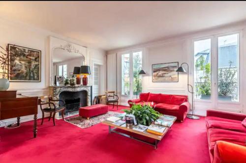 a living room with red furniture and a piano at 4 bedroom Luxury Eiffel Tower Apartment in Paris