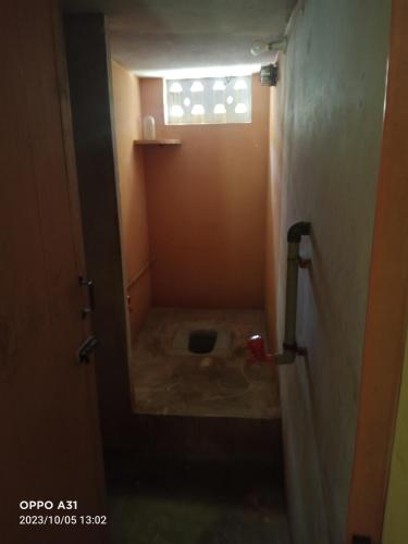 a small bathroom with a toilet in a room at Shanthi Illam in Madurai