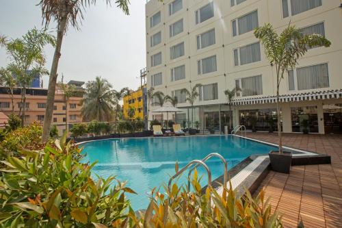 a swimming pool in front of a hotel at ARISTA BY AMBITION in Guwahati