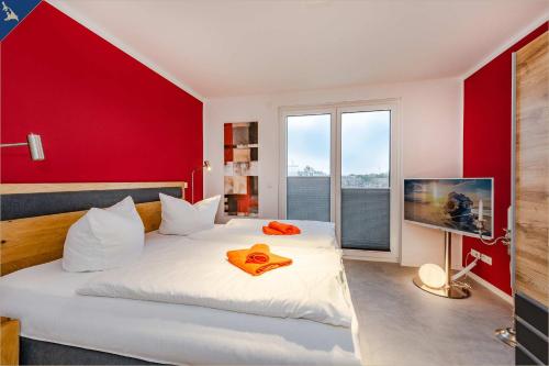 a bedroom with a white bed and a red wall at Ein Traum am Haff in Zirchow