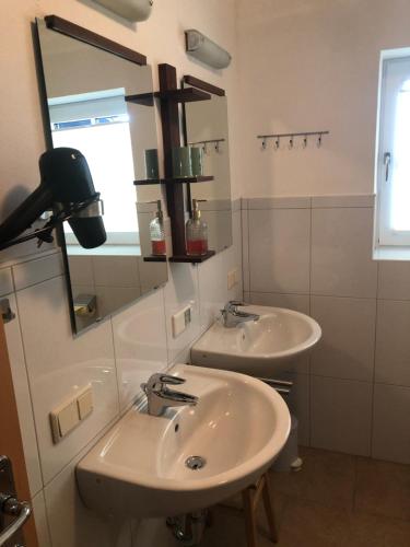 a bathroom with two sinks and a mirror at Schmiedlehnerhof in Birnberg