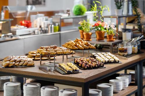 a table filled with different types of pastries and desserts at Clarion Congress Hotel České Budějovice in České Budějovice