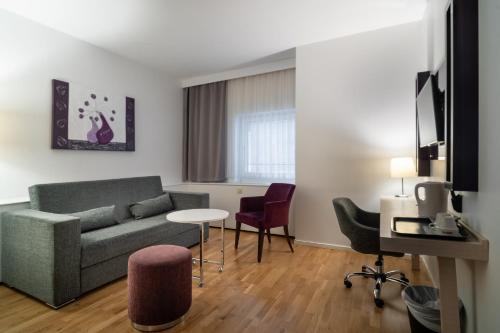 a living room with a couch and a table and chairs at Solna Park & Hotel in Solna