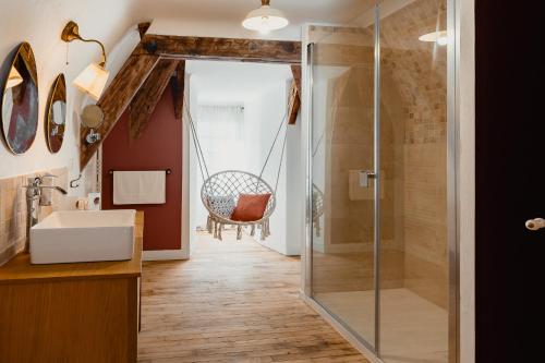 een badkamer met een douche en een schommelstoel bij Hôtel l'Abbaye in Saint-Cyprien