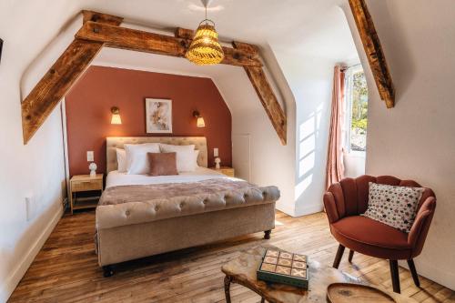 een slaapkamer met een groot bed en een stoel bij Hôtel l'Abbaye in Saint-Cyprien