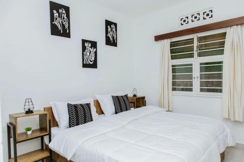 a bedroom with a white bed and a window at Neza Haven Kigali in Kigali