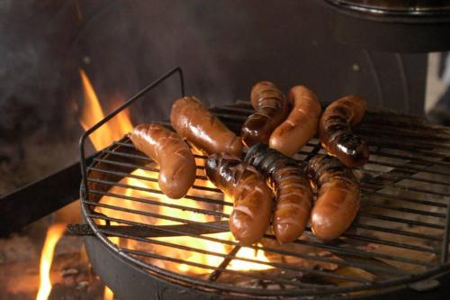 - un bouquet de hot-dogs et de saucisses sur un grill dans l'établissement the old school of halosenranta, à Kemijärvi