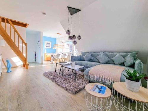 a living room with a blue couch and a table at Nimo 2 in Greetsiel