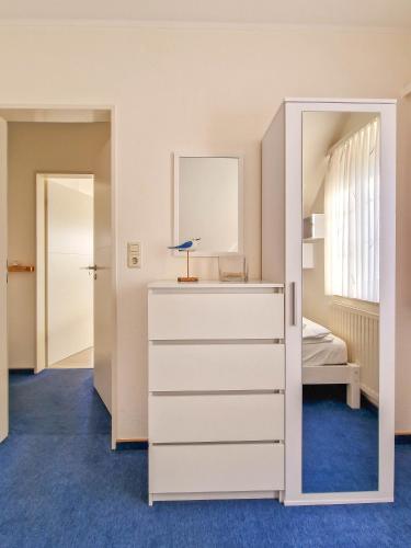 a bedroom with a dresser and a mirror at Nimo 2 in Greetsiel
