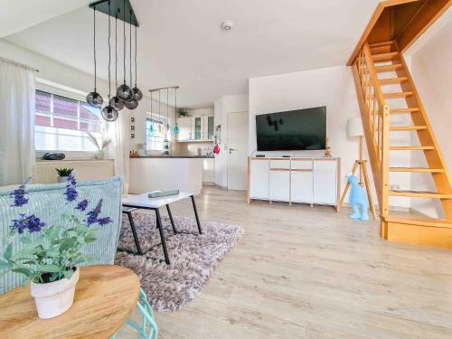 a living room with a couch and a tv and a kitchen at Nimo 2 in Greetsiel