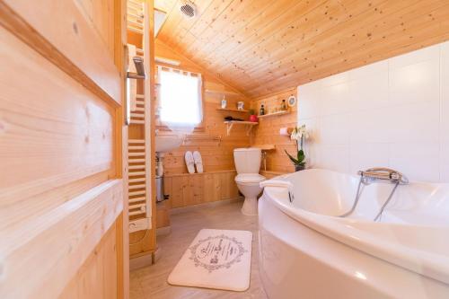 a bathroom with a tub and a toilet at Duplex - Chalet - 15 personnes in La Toussuire