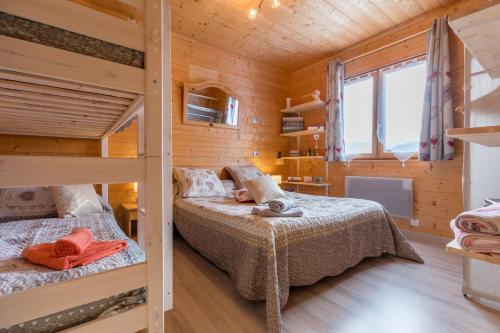 a bedroom with two bunk beds in a wooden cabin at Duplex - Chalet - 15 personnes in La Toussuire