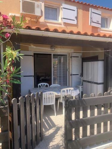 un patio avec une table et des chaises devant une maison dans l'établissement Ideal for your seaside vacation, à Frontignan