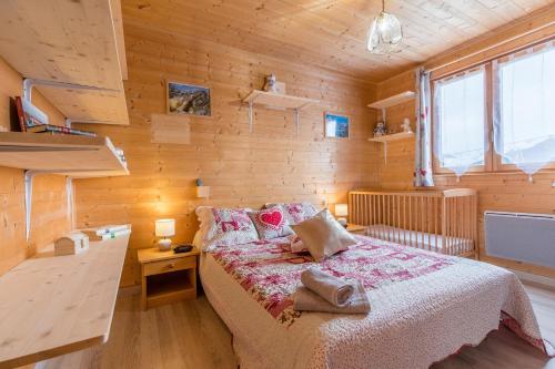 a bedroom with a bed and a wooden wall at Appartement rdc - Chalet individuel in La Toussuire