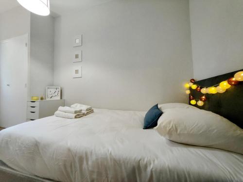 - une chambre avec un lit blanc éclairé dans l'établissement Paris II - Séjour à Auxerre, à Auxerre