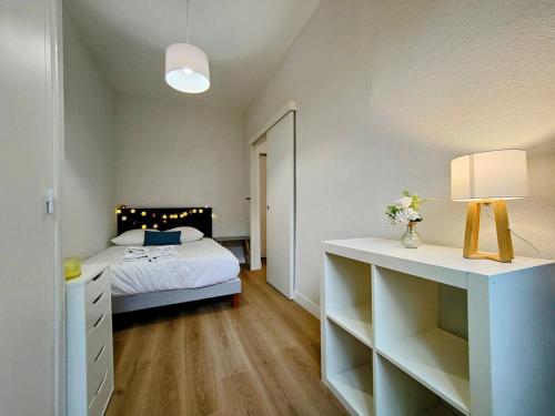 une chambre avec un lit et une table avec une lampe dans l'établissement Paris II - Séjour à Auxerre, à Auxerre