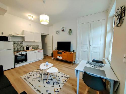 un salon avec une table et une cuisine dans l'établissement Paris II - Séjour à Auxerre, à Auxerre