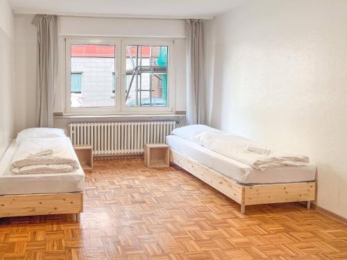 zwei Einzelbetten in einem Zimmer mit Fenster in der Unterkunft T&K Apartments - Duisburg - 3 Zimmer Apartment in Duisburg