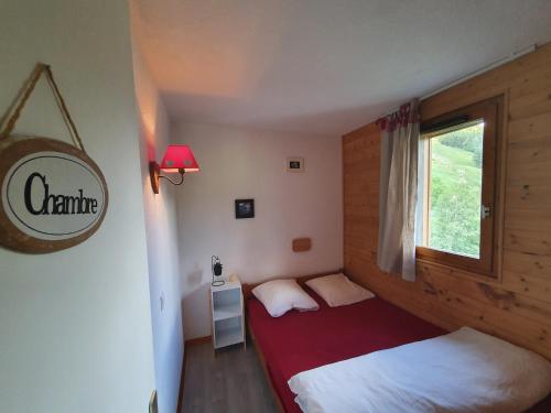 une chambre avec deux lits et une fenêtre dans l'établissement Le Soleil - 412 - Appart belle vue - 4 pers, à Les Deux Alpes