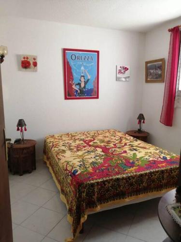- une chambre avec un lit et une affiche murale dans l'établissement Maison près de la plage, à Penta-di-Casinca