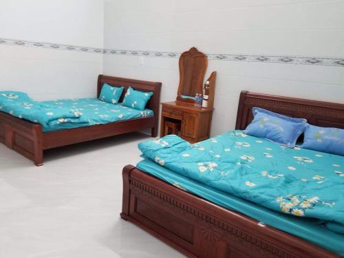 a bedroom with two beds with blue comforter at Phúc Nguyễn House in Lagi
