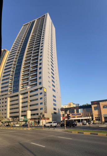 a tall white building with a street in front of it at F30,R3,Sunrise on the beach,1room inside 3bedroom apartment,(separate washroom outside) in Ajman 